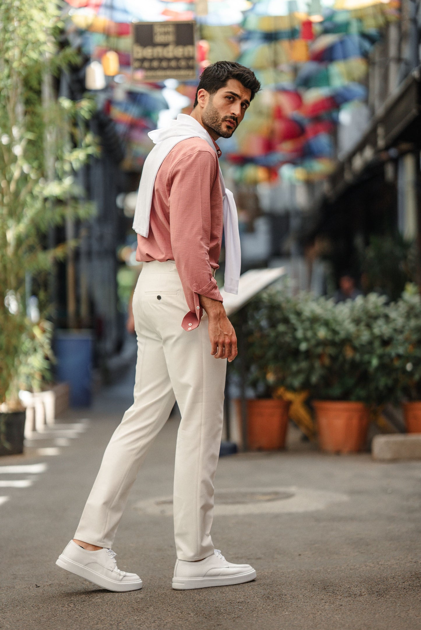 Man wearing the HolloMen Tulum Pink Linen Shirt, styled with a button-down collar, standing in a clean, minimal setting, perfect for summer occasions.