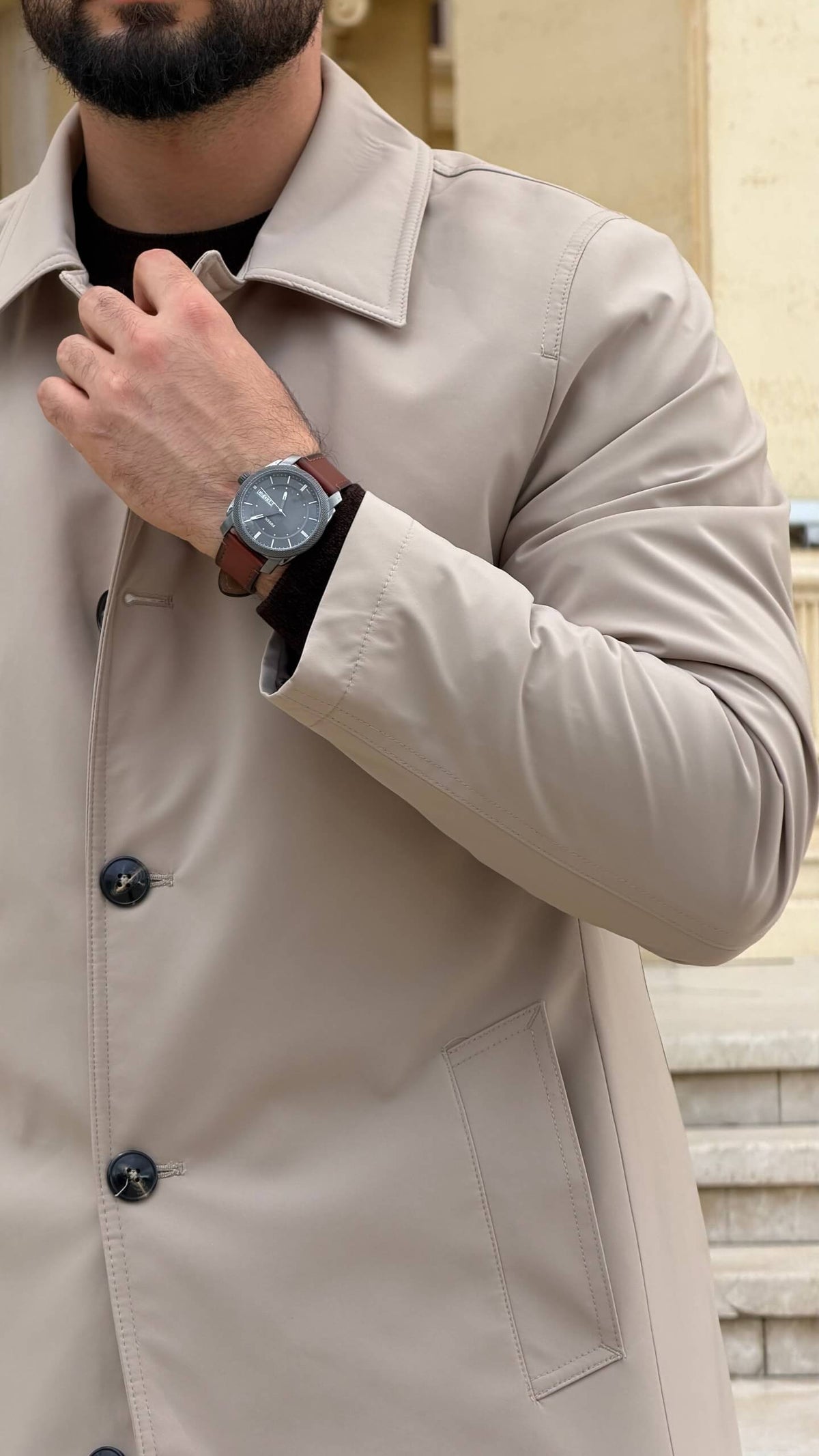 Men wearing a beige single breasted trench coat with button closure and side pockets
