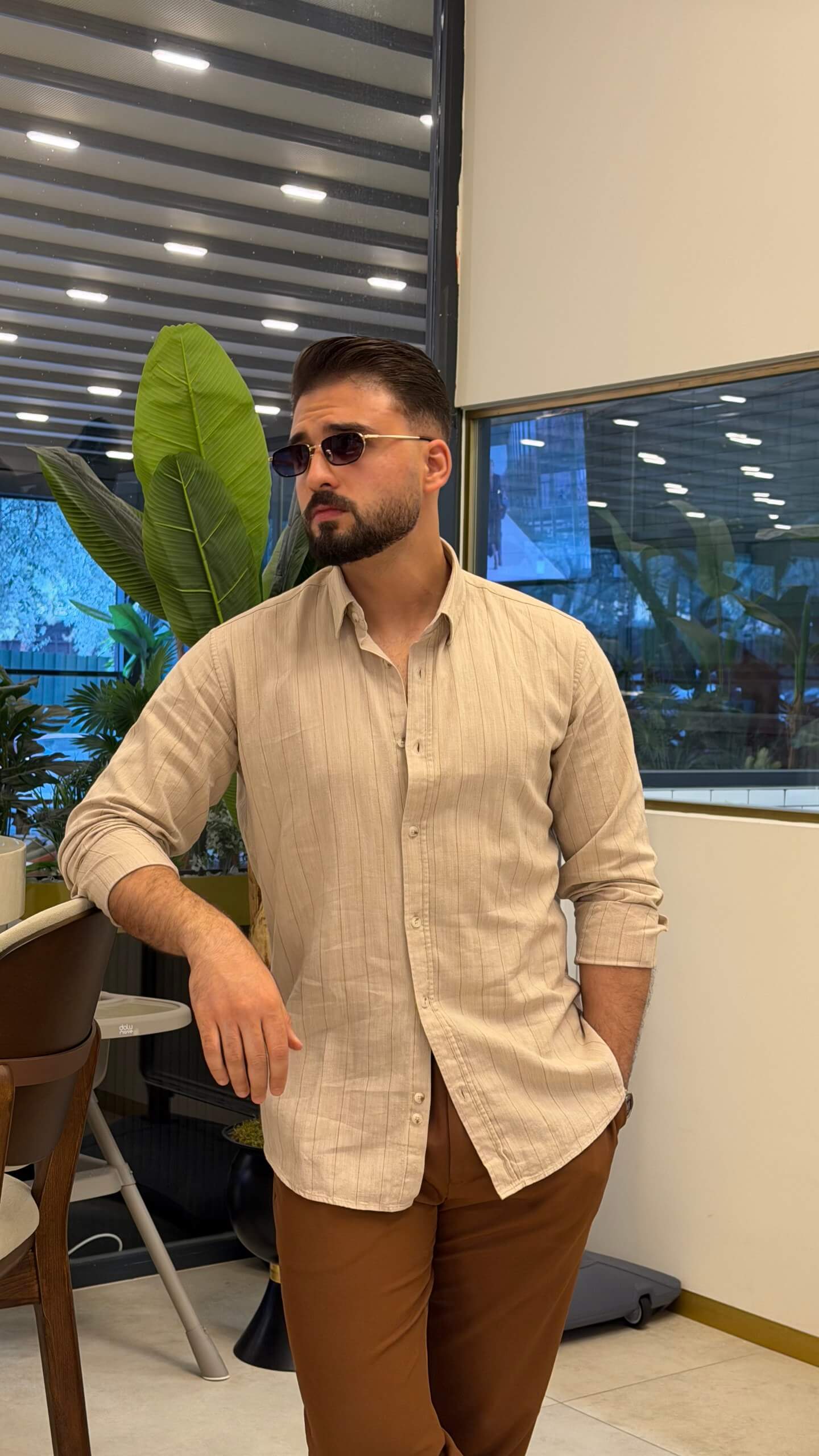 Men’s beige pinstripe long sleeve cotton shirt styled with brown trousers and loafers