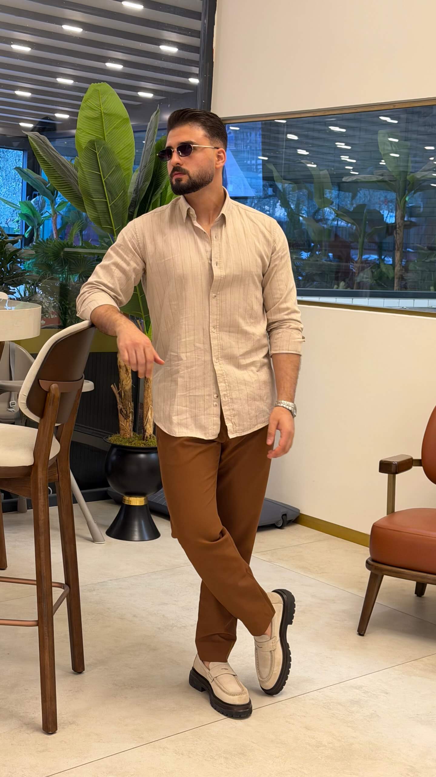 Men’s beige pinstripe long sleeve cotton shirt styled with brown trousers and loafers