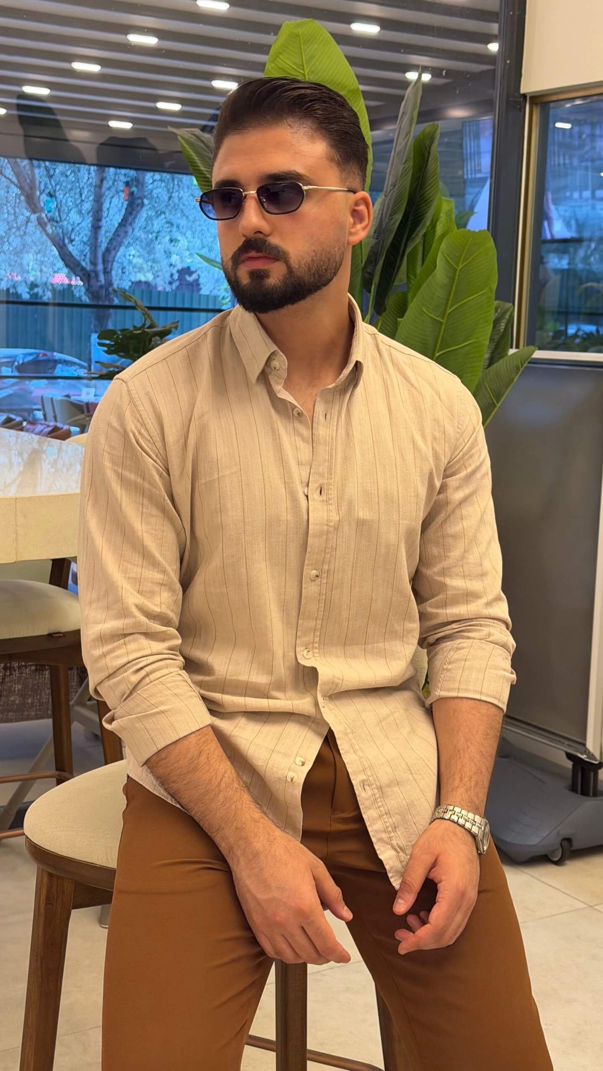 Men’s beige pinstripe long sleeve cotton shirt styled with brown trousers and loafers