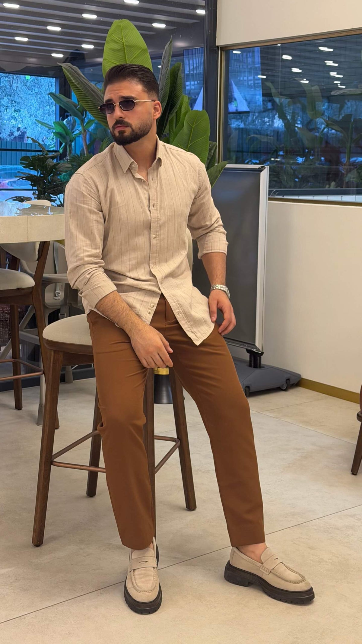Men’s beige pinstripe long sleeve cotton shirt styled with brown trousers and loafers