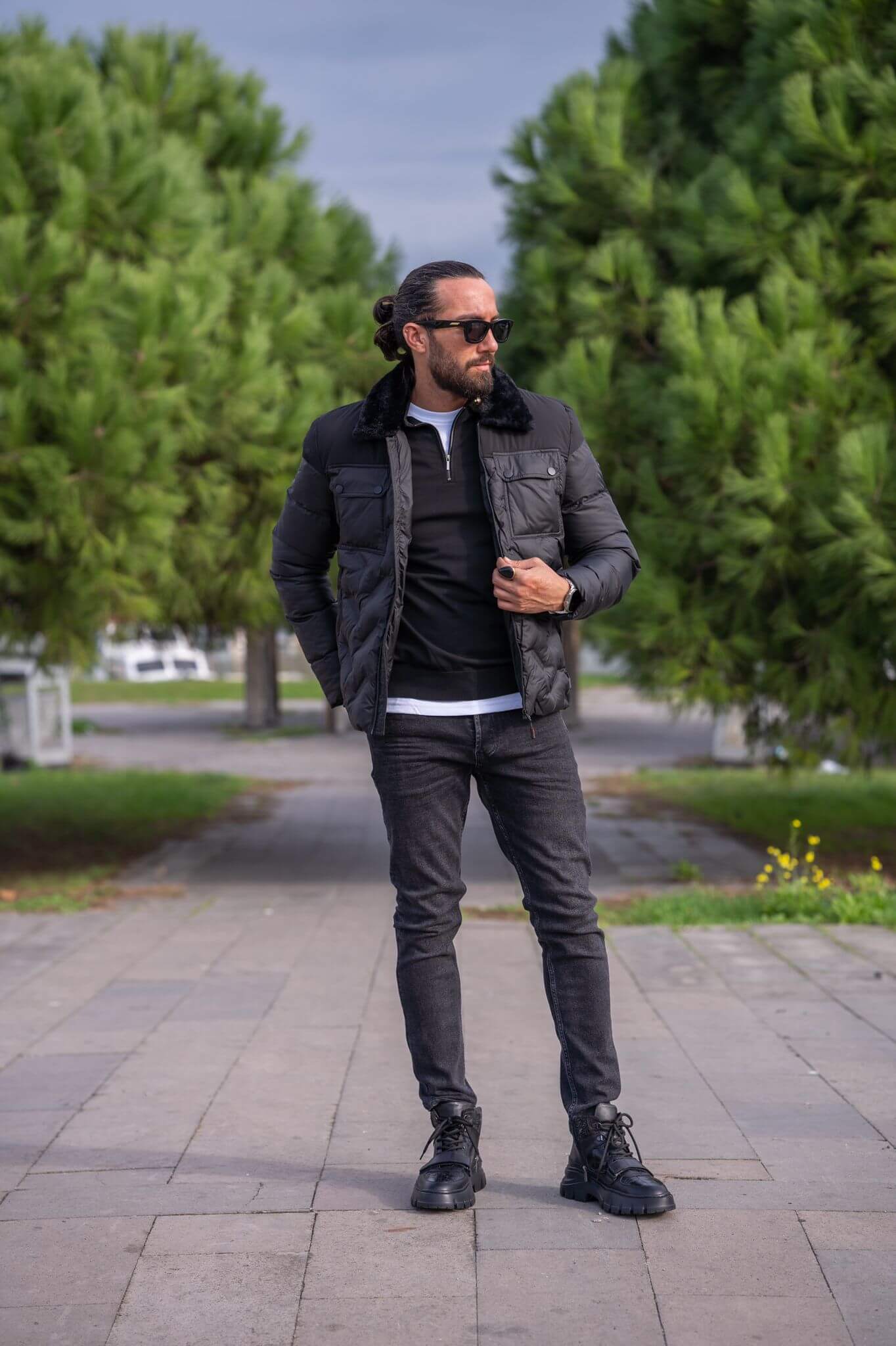 A stylish male model confidently wears our sleek black bomber jacket, exuding urban cool vibes."
