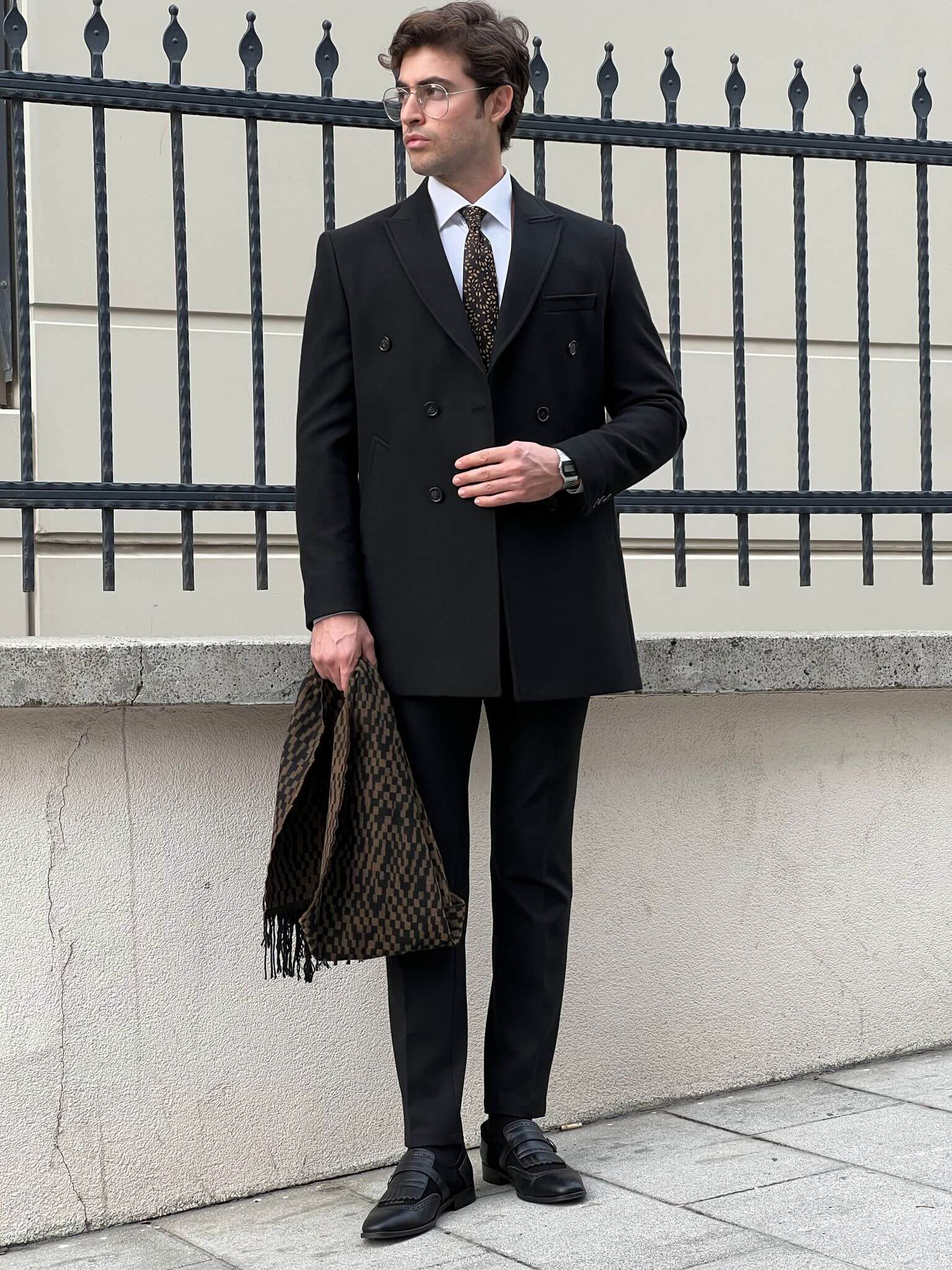Elegance in motion: our male model effortlessly rocks the classic black coat.