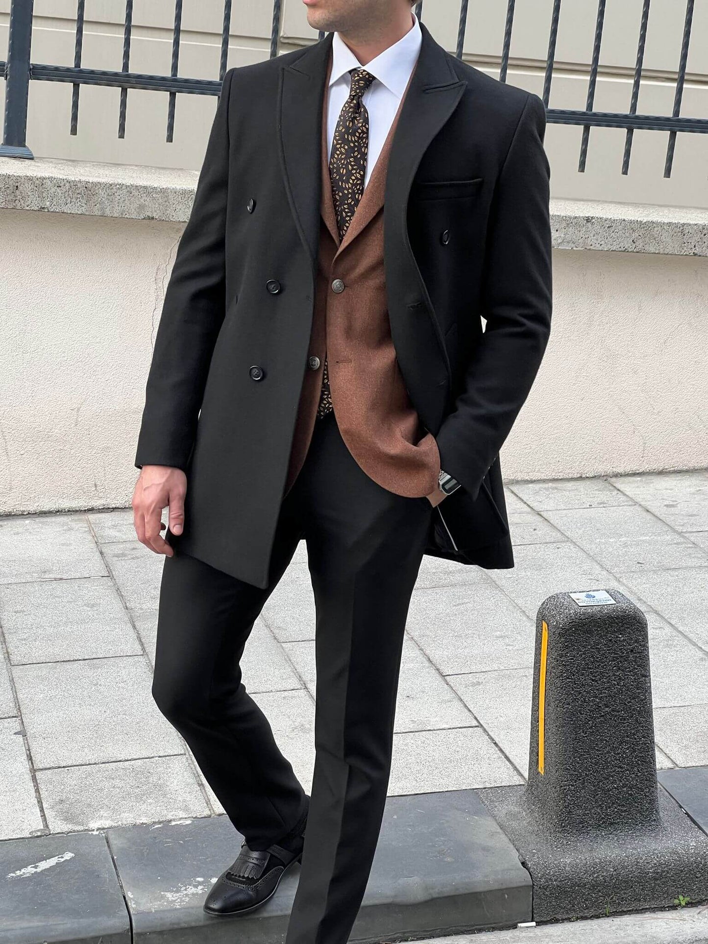 Elegance in motion: our male model effortlessly rocks the classic black coat.