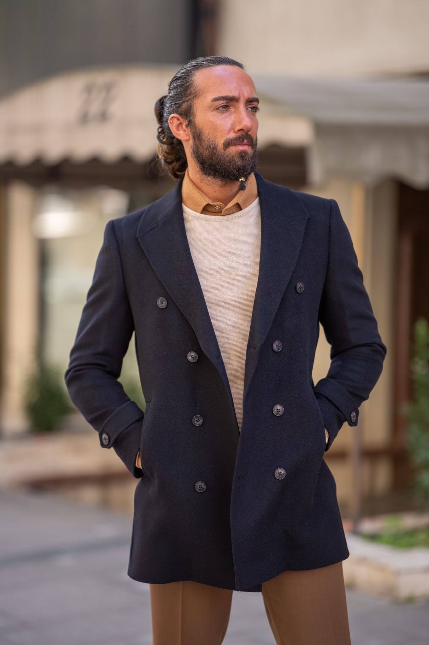 A confident male model elegantly showcasing our sleek black coat, exuding sophistication and style