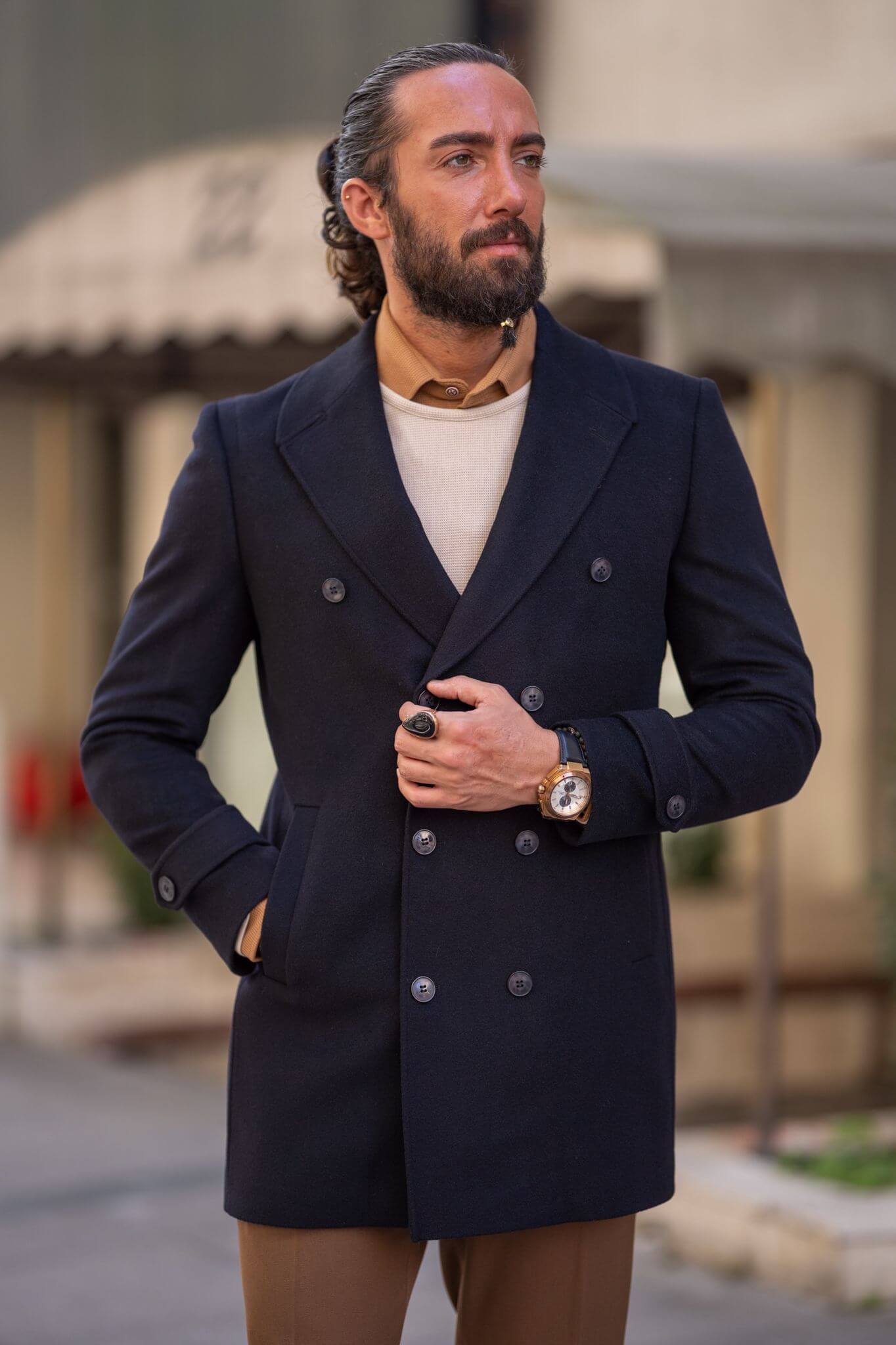 A confident male model elegantly showcasing our sleek black coat, exuding sophistication and style