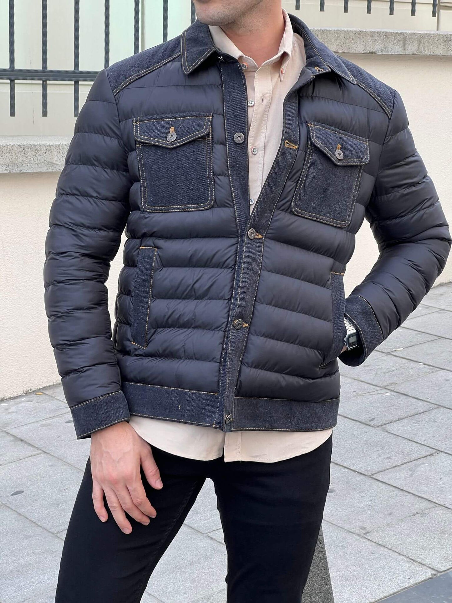 Stylish male model confidently wears a sleek black denim coat, exuding urban cool vibes.