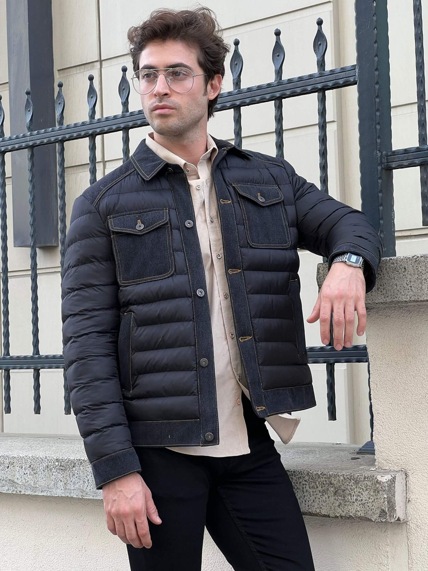 Stylish male model confidently wears a sleek black denim coat, exuding urban cool vibes.