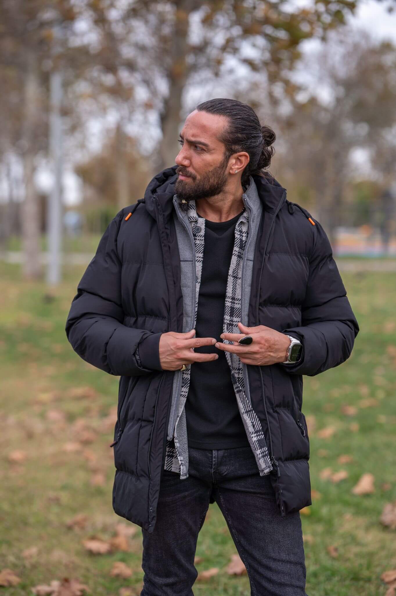 Striking male model confidently displays the sleek and stylish black puffer jacket.