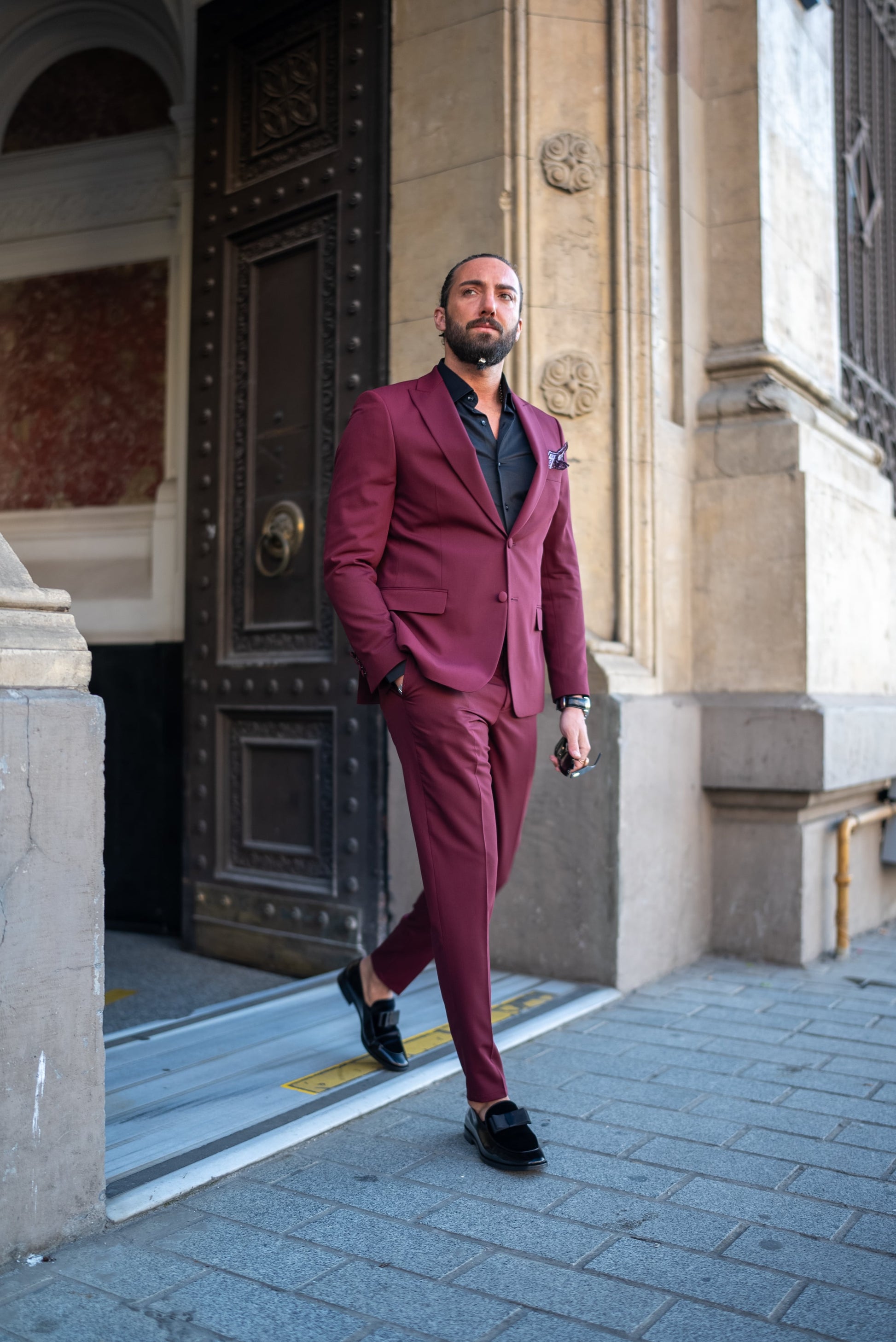A Burgundy Brilliance Tuxedo Suit worn by a model