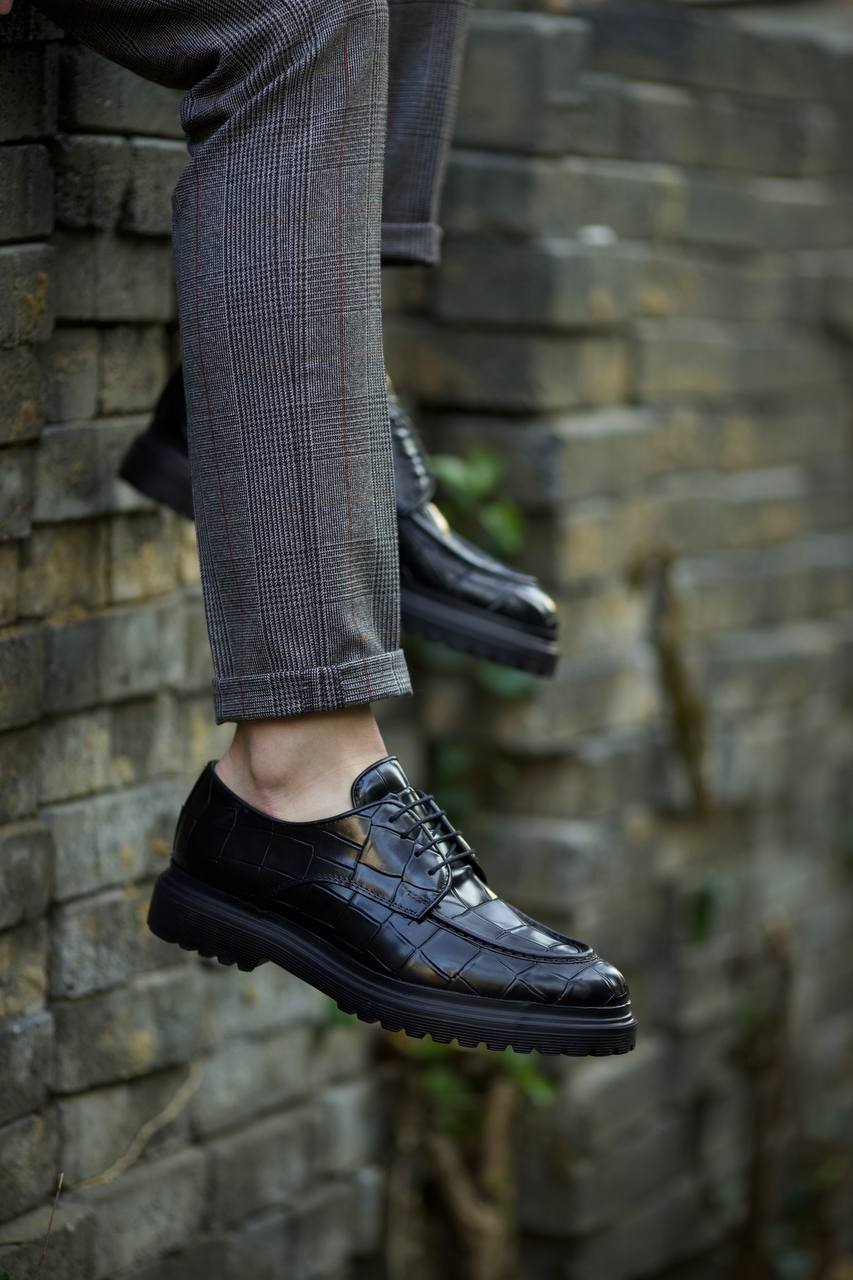 Black croc-embossed leather derby shoes with EVA sole, worn with tailored grey check trousers. 