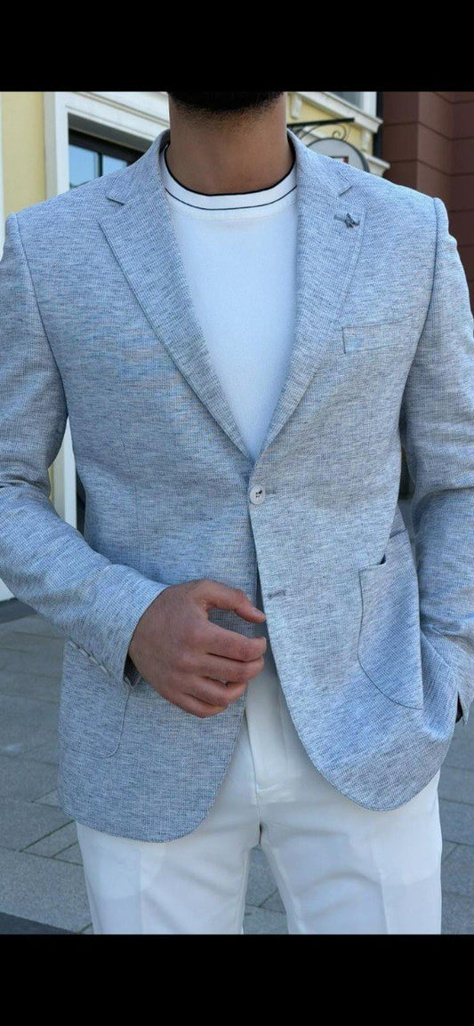 Men’s indigo blue slim-fit blazer styled with white trousers and a t-shirt, showcasing a lightweight textured fabric for smart-casual wear.