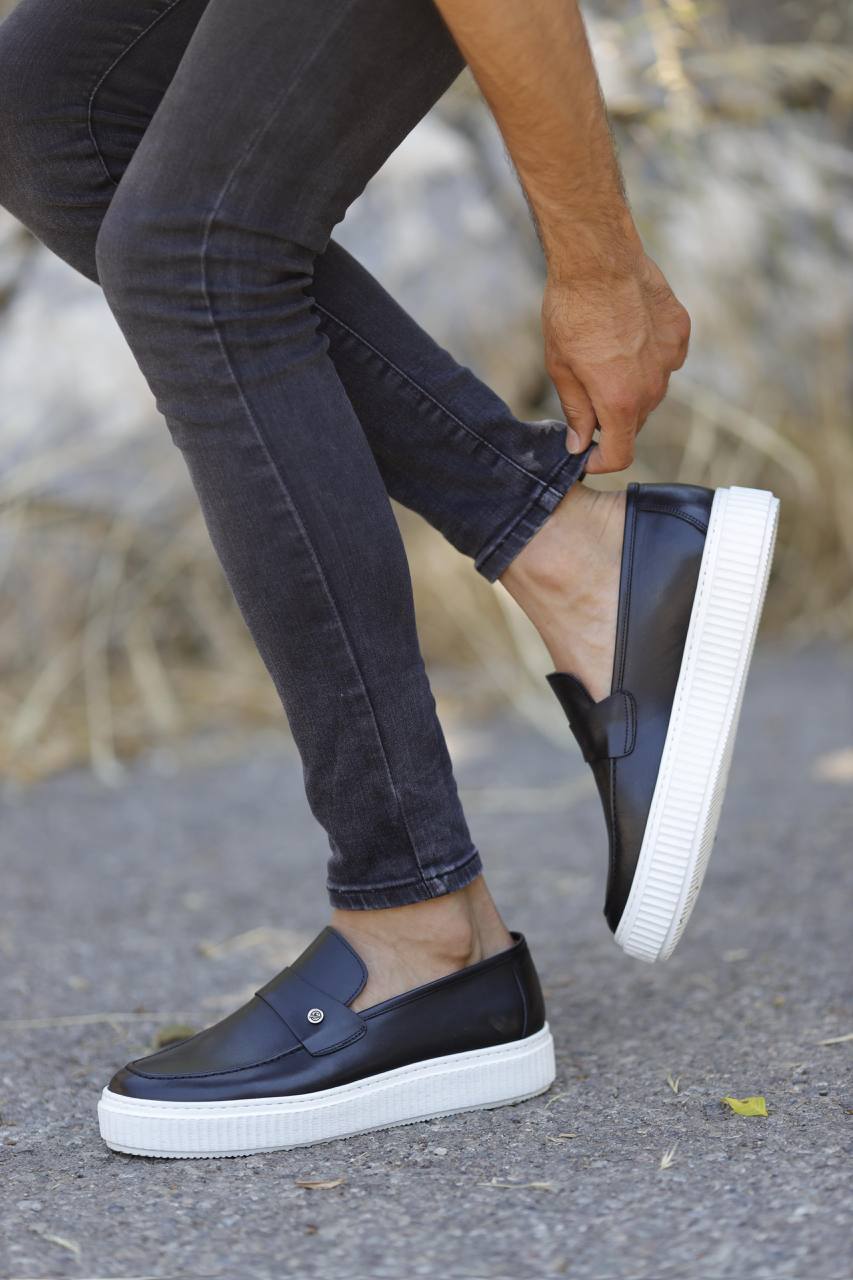Navy blue leather slip-on loafers with white EVA soles, styled with skinny black jeans