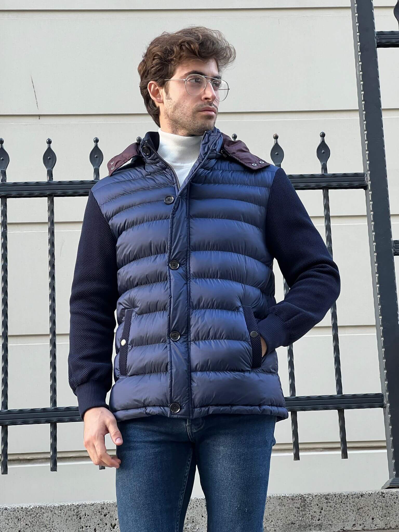 Modern and refined: Male fashion model in a textured navy blue knit coat, a timeless choice for the season.