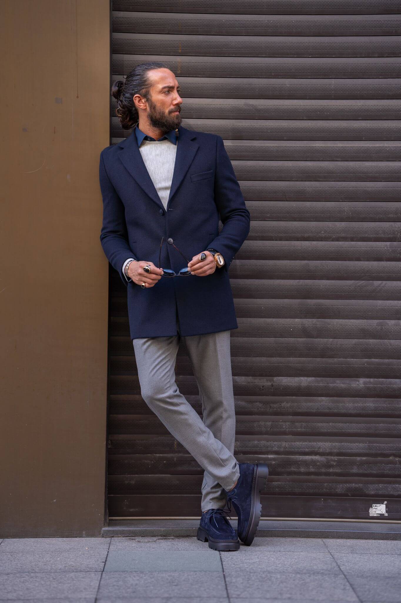 Confident male model exudes sophistication in our impeccably tailored navy blue coat.