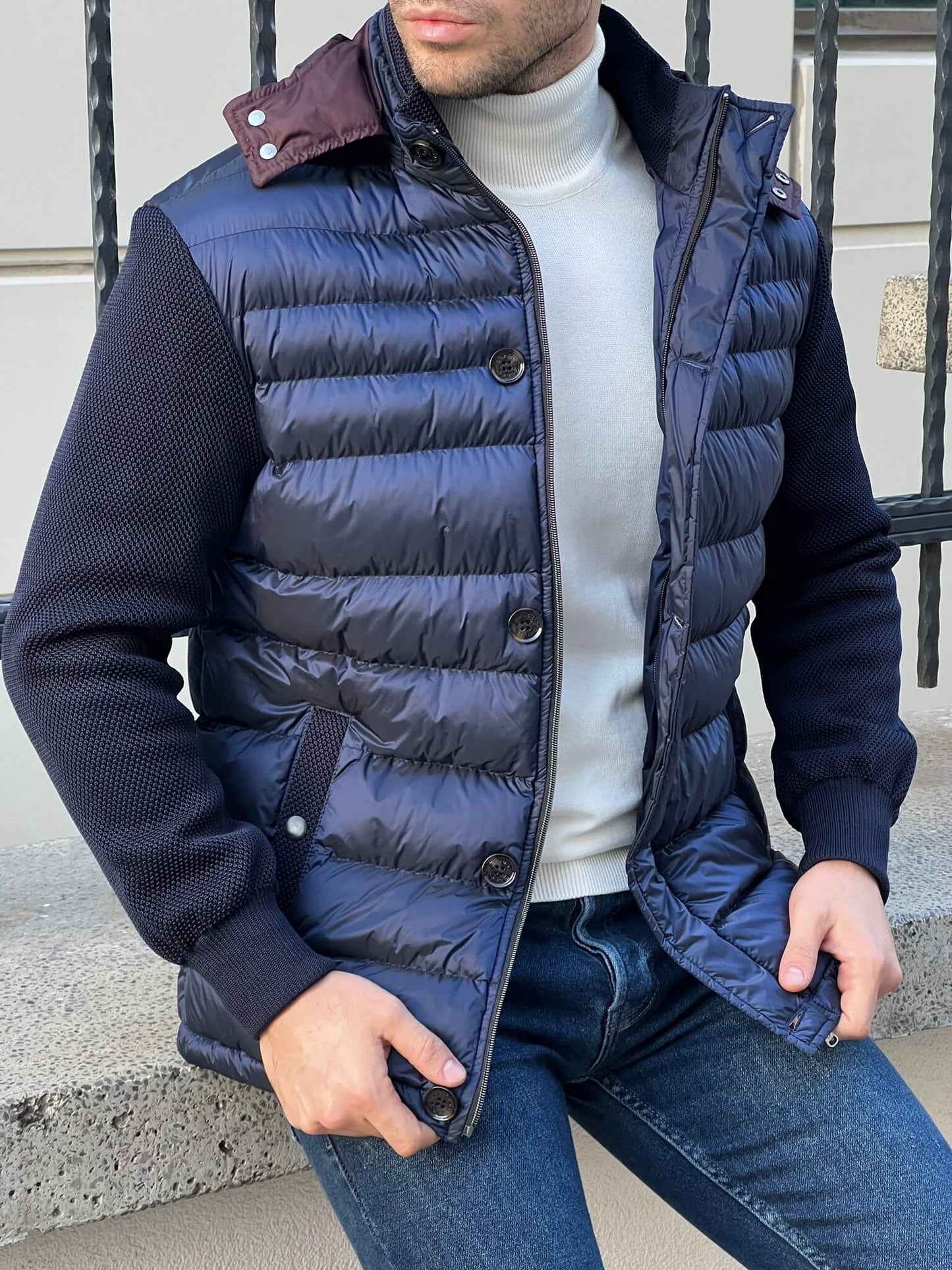 Modern and refined: Male fashion model in a textured navy blue knit coat, a timeless choice for the season.