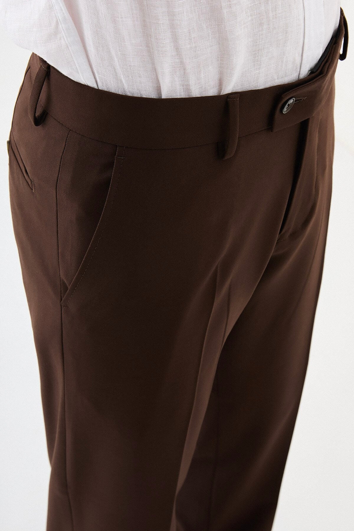 Men wearing brown slim-fit classic trousers, styled with formal shoes and a dress shirt, ideal for business and formal events.