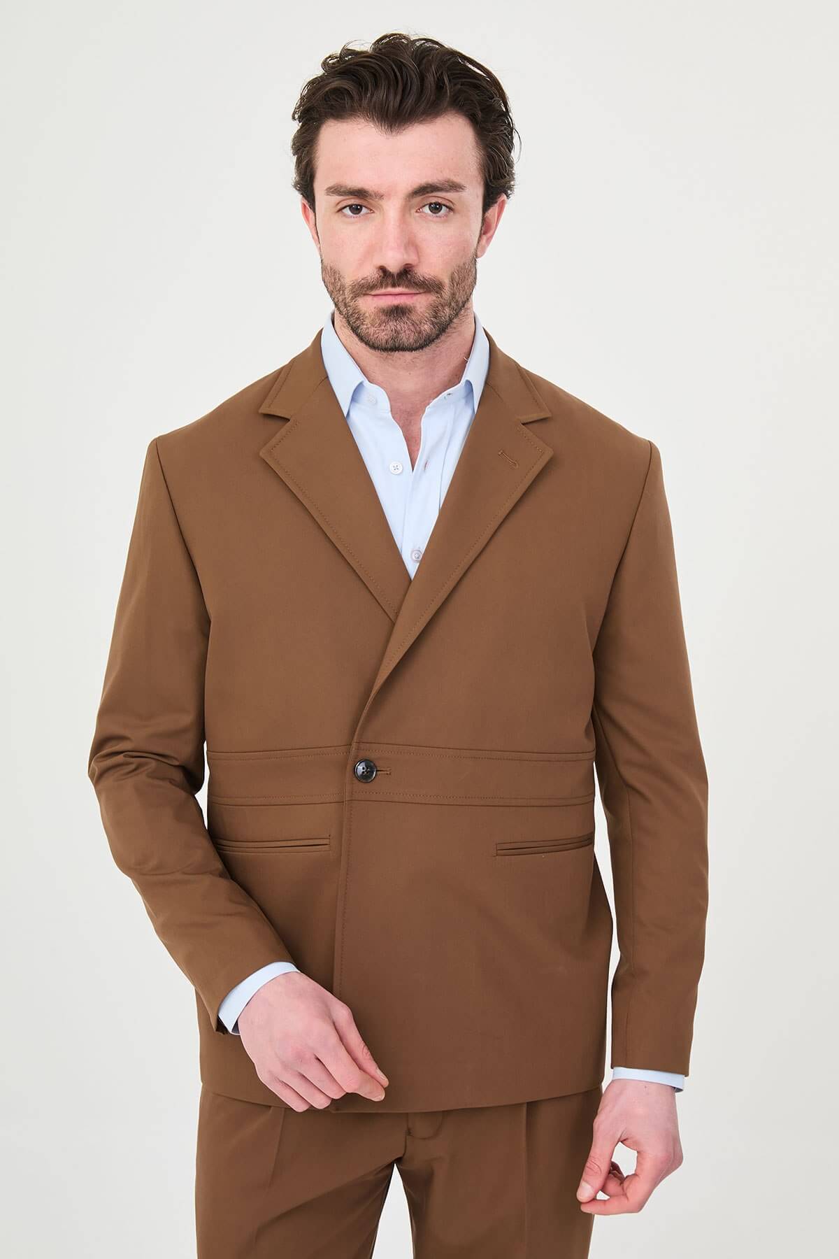 Man wearing a camel slim-fit two-piece suit, tailored for summer, standing outdoors, front view.