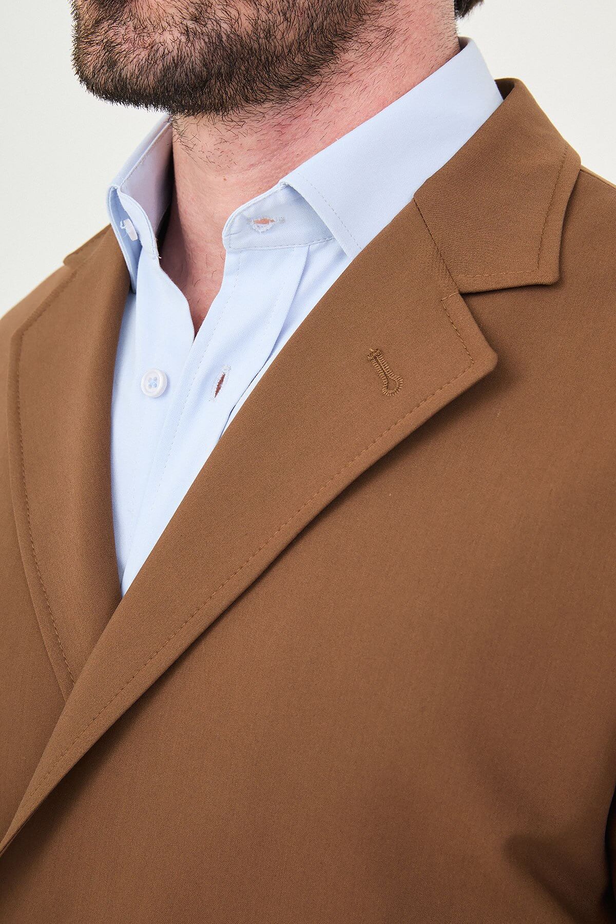 Man wearing a camel slim-fit two-piece suit, tailored for summer, standing outdoors, front view.