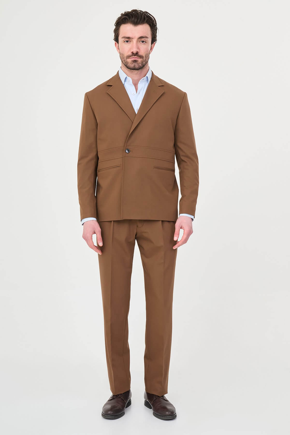 Man wearing a camel slim-fit two-piece suit, tailored for summer, standing outdoors, front view.