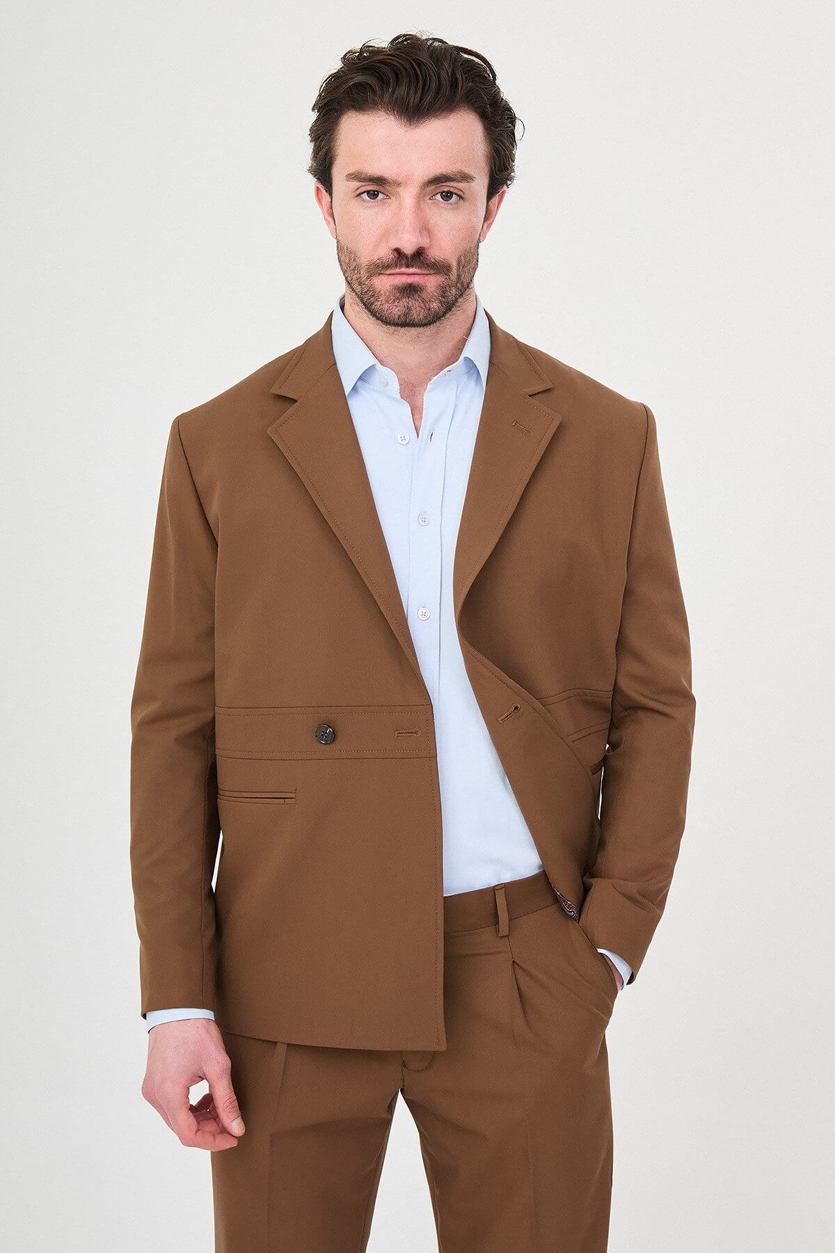 Man wearing a camel slim-fit two-piece suit, tailored for summer, standing outdoors, front view.