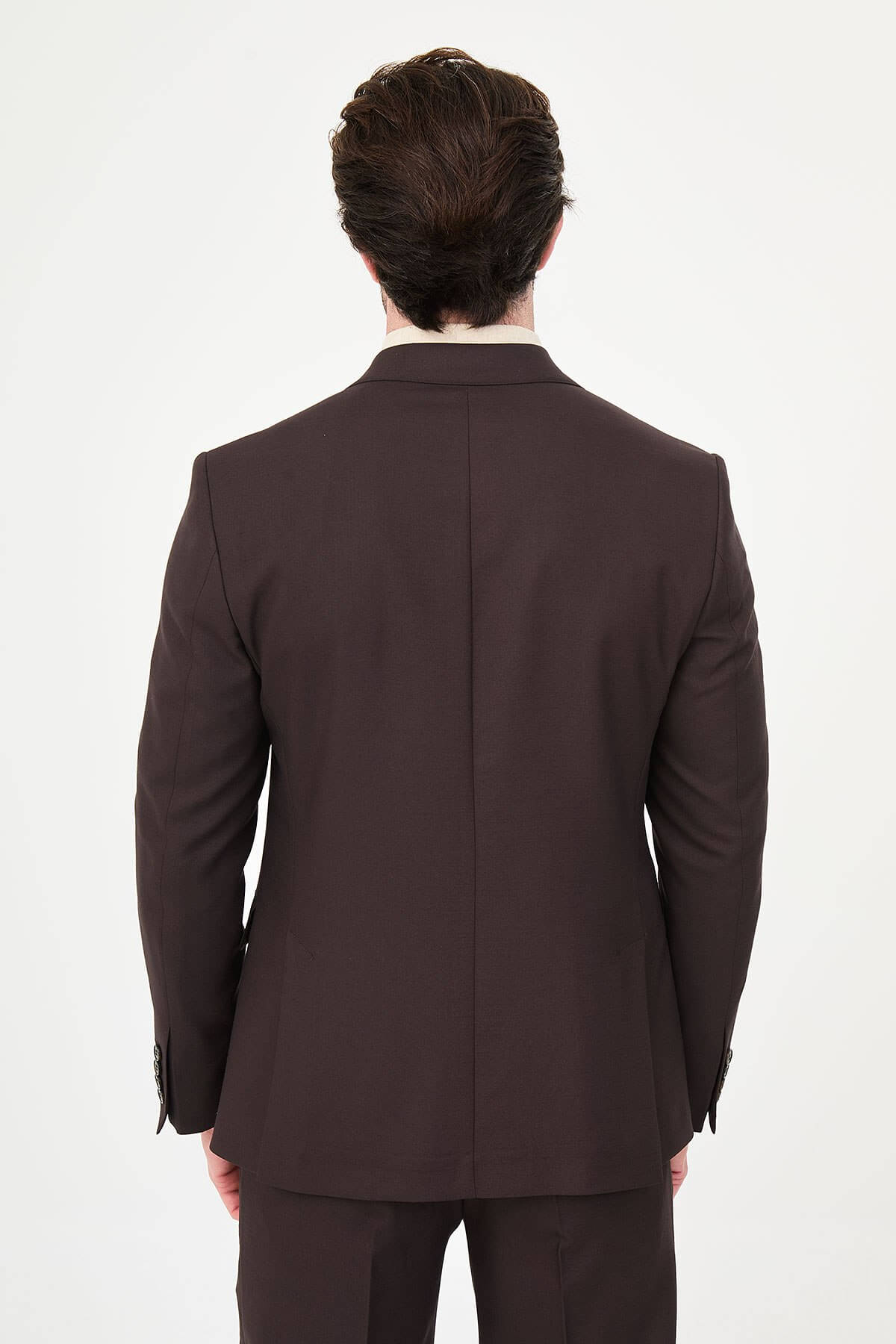 a brown slim-fit double-breasted linen-blend suit with peak lapels, contrast pick stitching, matching trousers, and an open-collar cream shirt.
