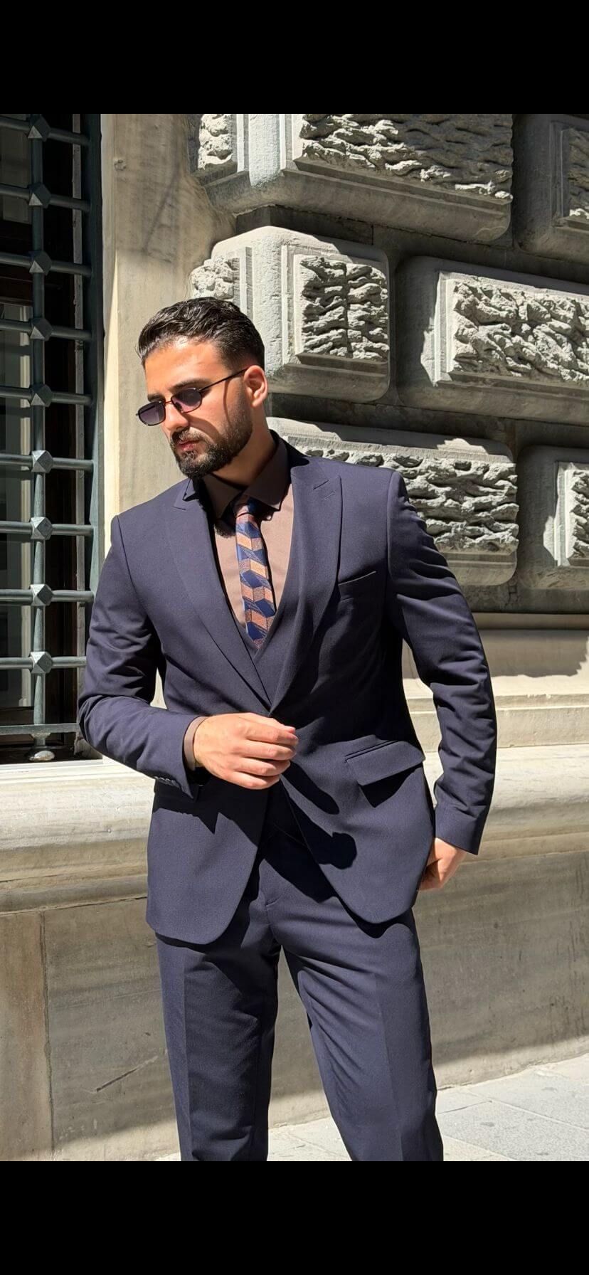 Men’s navy blue three piece suit with tailored jacket, matching waistcoat, trousers, and elegant formal design for weddings, business, and special occasions.