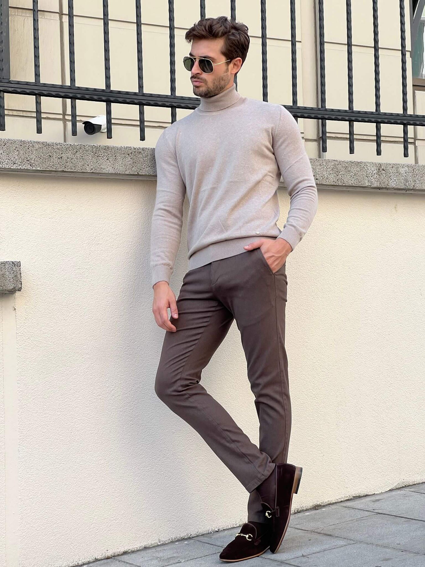 A beige turtleneck sweater with a folded collar, showcasing its soft, ribbed texture