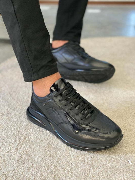 Close-up of black leather lace-up sneakers with a rugged sole, photographed under natural light, showcasing clean stitching and a modern silhouette from the HolloMen Fall-Winter collection.