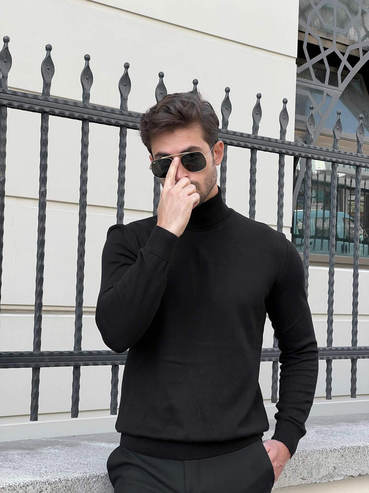 A black turtleneck sweater with a ribbed texture, worn by a model