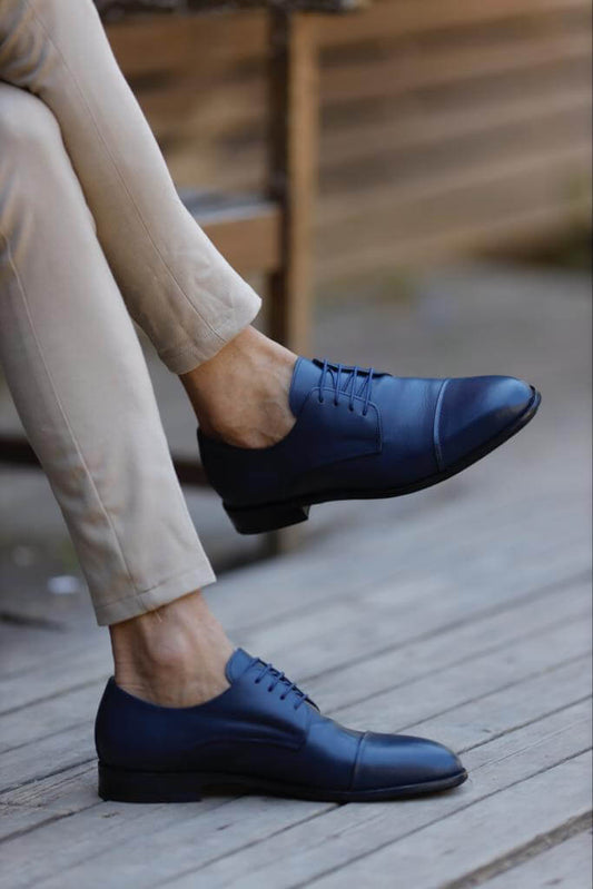 Glossy blue patent leather derby shoes with a modern lace-up silhouette and ultra-light neo-lite sole, styled for elegant Spring–Summer occasions.