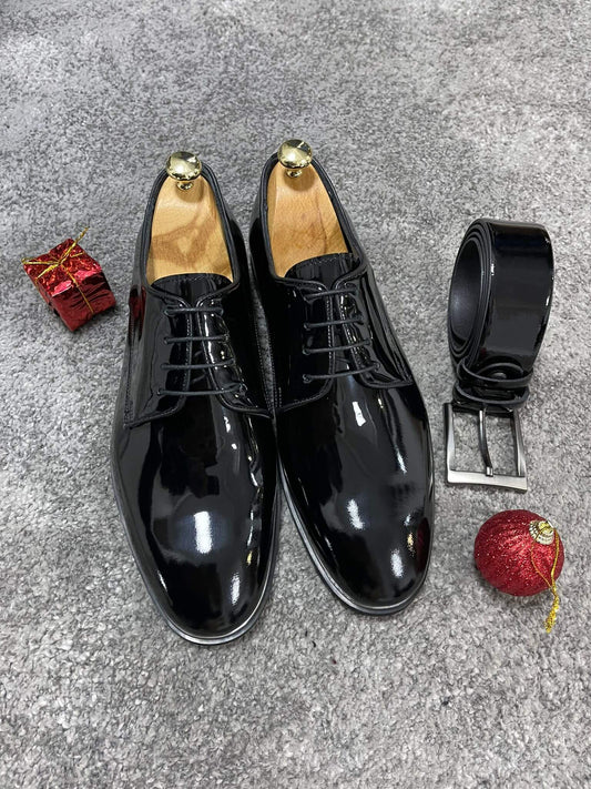 Glossy black patent leather derby shoes with lace-up detail, perfect for formal events and polished fall-winter outfits.