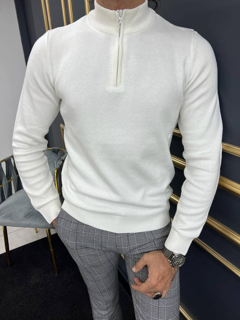 A combed white sweater, featuring a soft and textured knit pattern. The sweater has a relaxed fit and a cozy, ribbed collar.