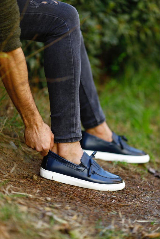 Dark blue leather loafers with tassel detailing and a white EVA sole, offering a smart-casual look with lightweight comfort.