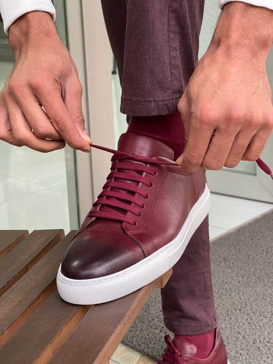 Claret red leather sneakers with lace-up design and white EVA sole, photographed in studio lighting to highlight texture and bold color—ideal for smart-casual styling.
