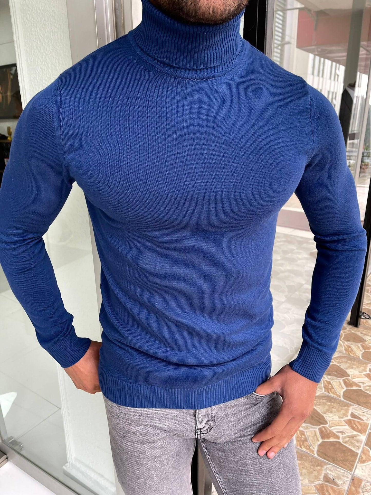 An elegant, sax turtleneck sweater made of high-quality fabric worn by a model