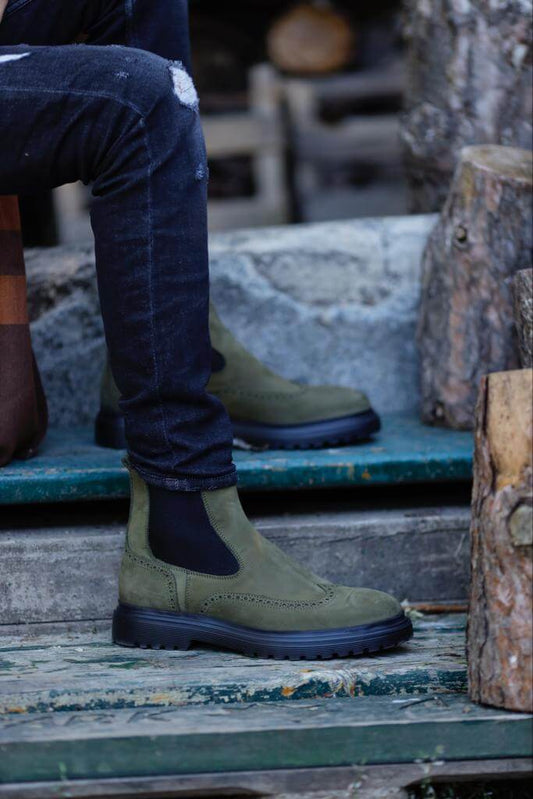 khaki nubuck Chelsea boots with elastic sides and black rugged soles, styled with black distressed jeans.