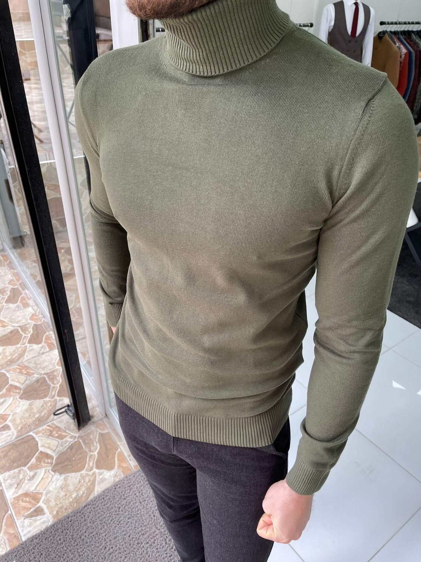 A khaki turtleneck sweater, a cozy and stylish garment with a high, folded collar, in a warm khaki color."