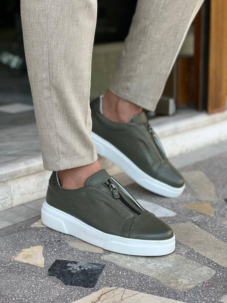 Khaki leather sneakers featuring a side zipper and minimalist laces, set on a lightweight EVA sole, styled in natural lighting against a neutral background.