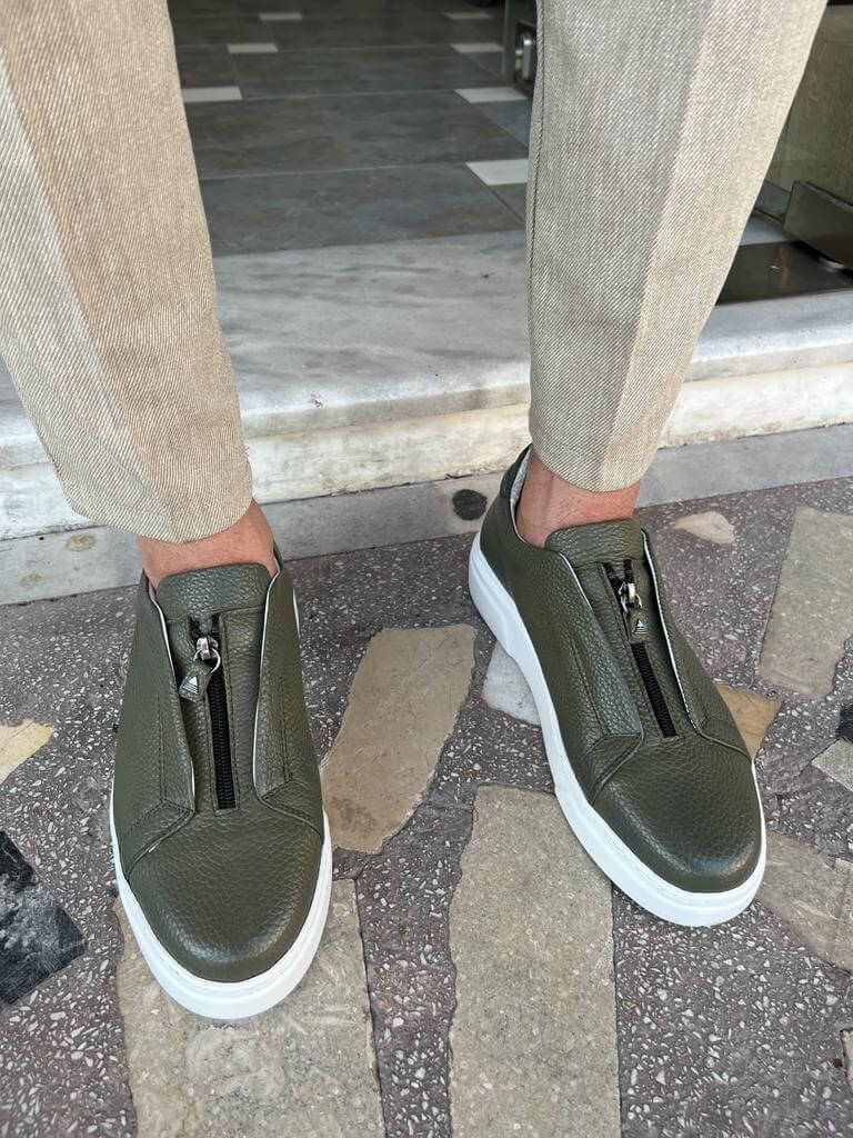 Khaki leather sneakers featuring a side zipper and minimalist laces, set on a lightweight EVA sole, styled in natural lighting against a neutral background.