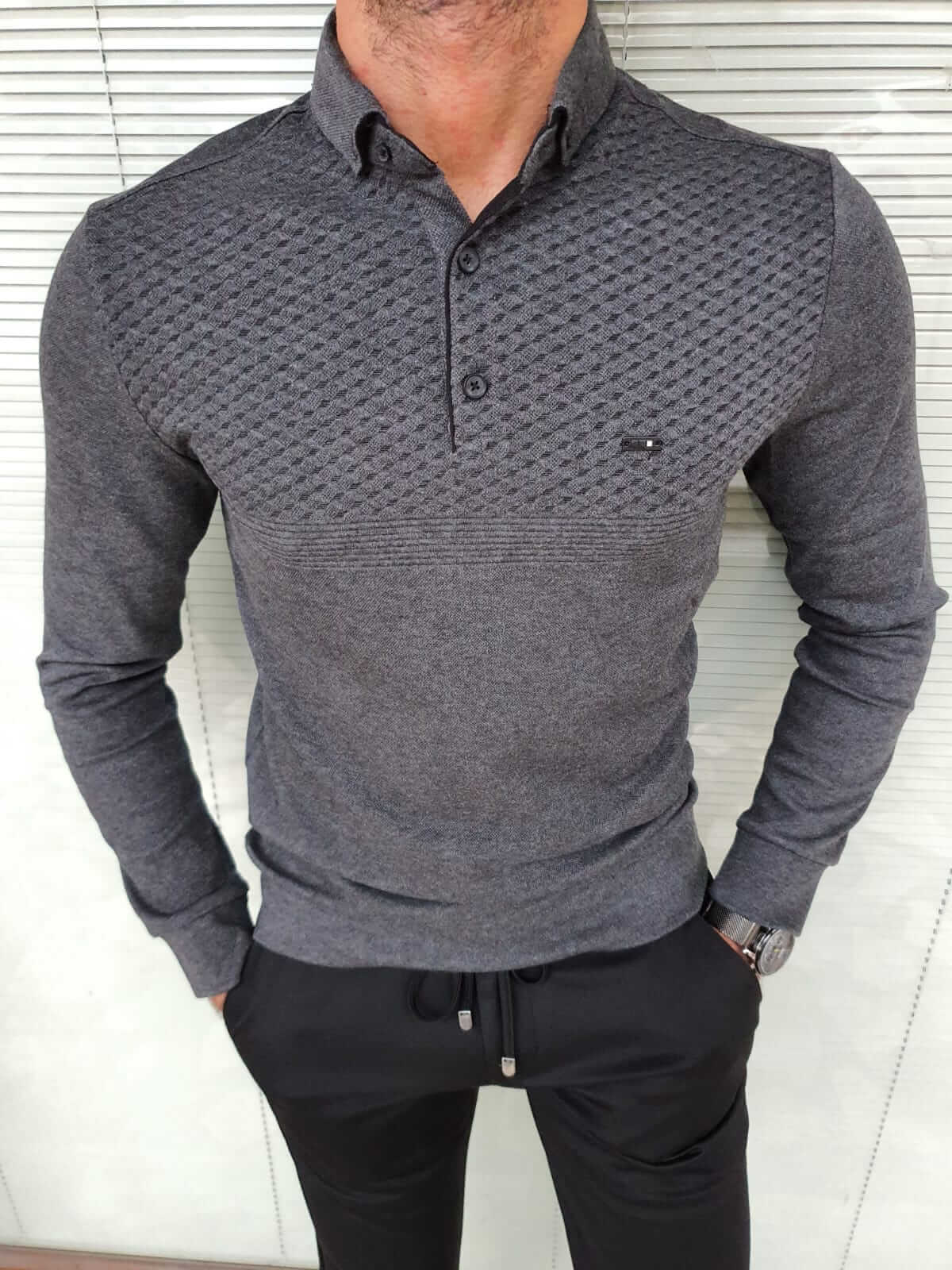 A  long-sleeved gray combed knitwear. The knit fabric has a soft and textured appearance