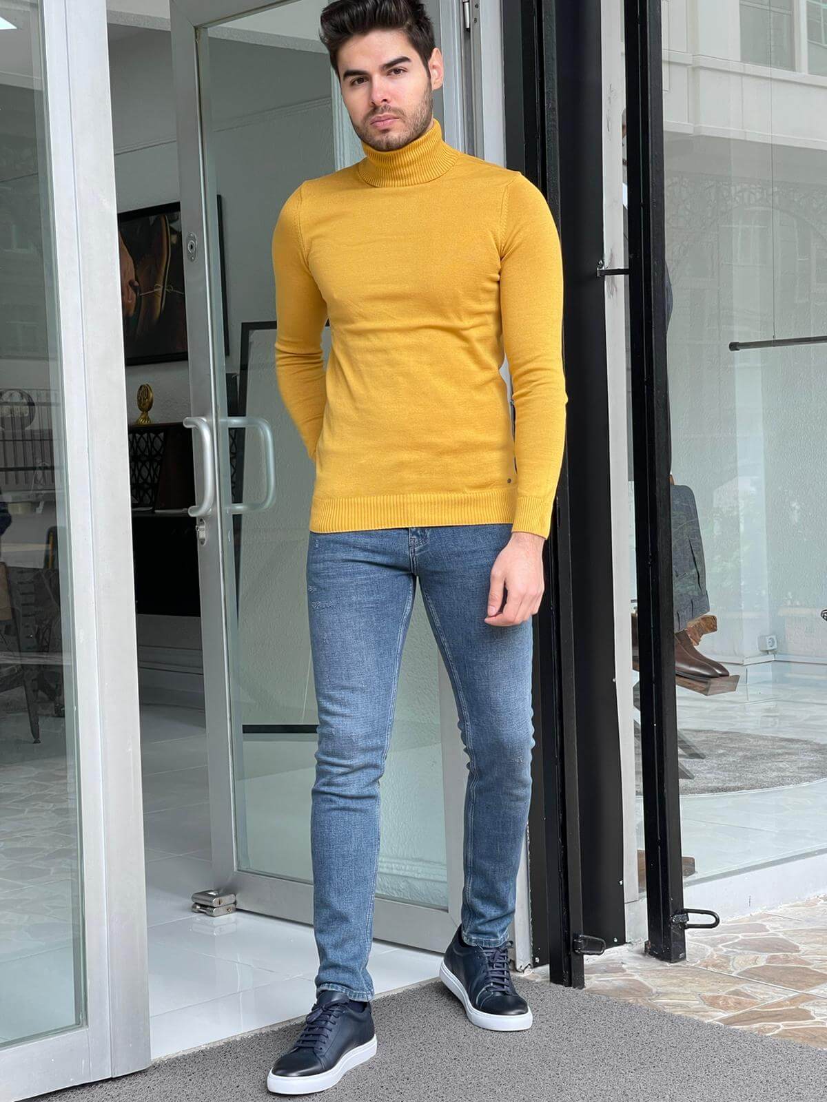 A stylish yellow turtleneck sweater worn by a model, showcasing its vibrant color and modern design."