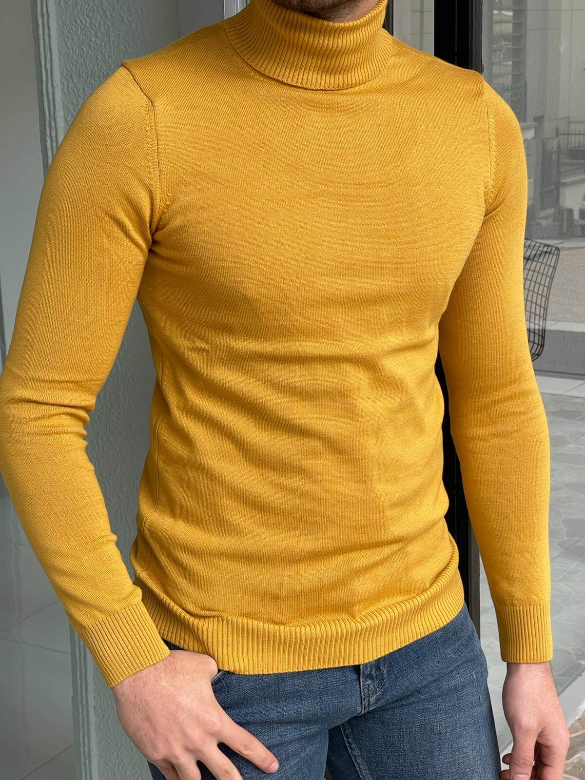 A stylish yellow turtleneck sweater worn by a model, showcasing its vibrant color and modern design."