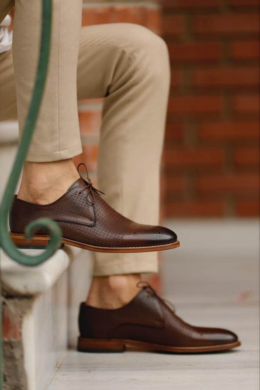 Glossy brown patent leather derby shoes with lace-up detailing and a sleek neo-lite sole, styled for Spring–Summer occasions with classic tailoring.