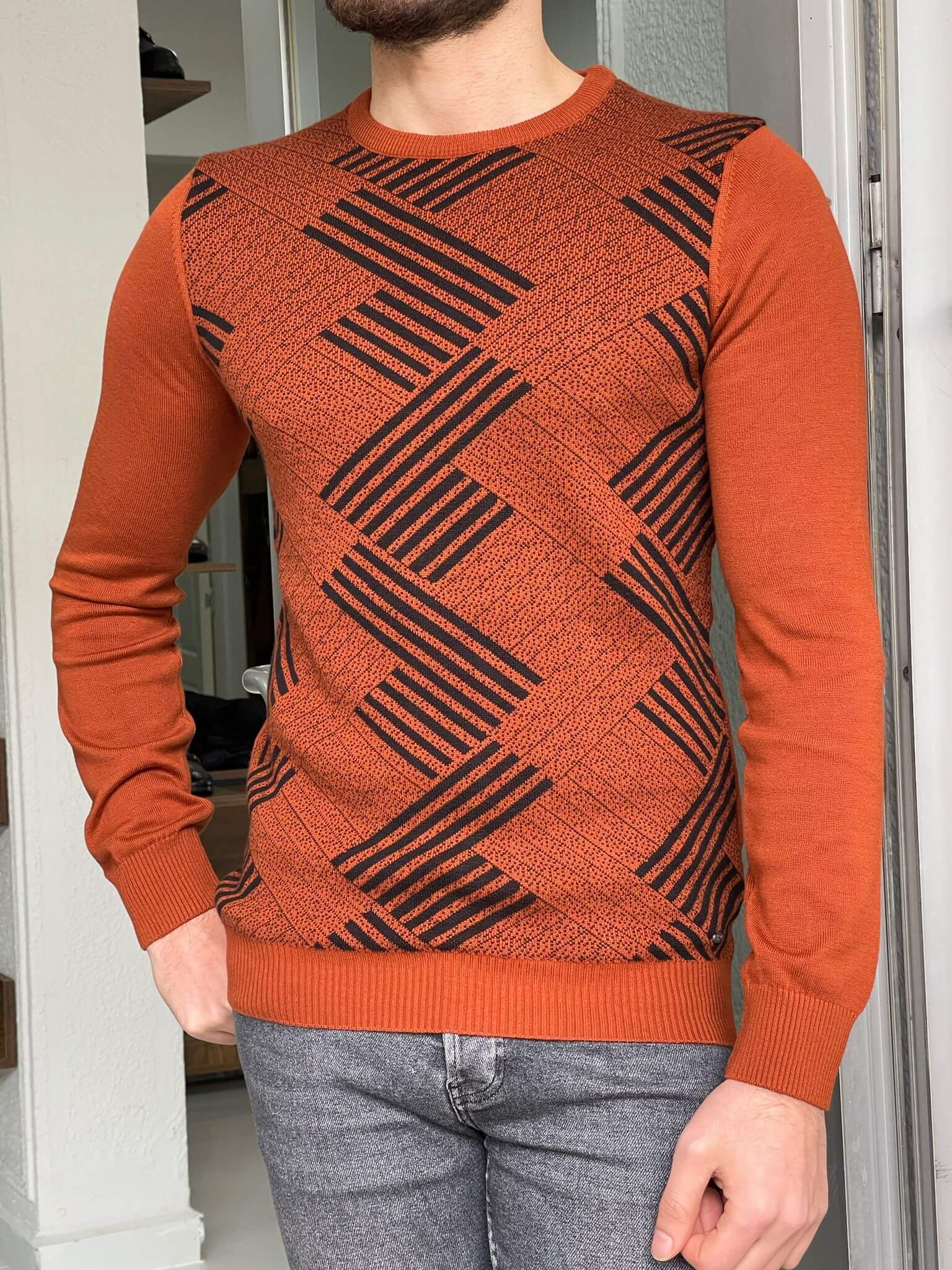 A crewneck sweater with a striking patterned tile design, combining vibrant colors and geometric shapes."