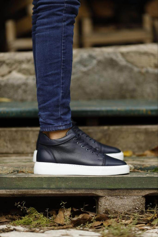 blue leather high-top sneakers worn with navy jeans, standing on a rustic outdoor stairway